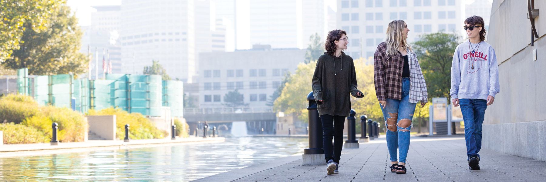 Three people walking along the canal in downtown Indianapolis.