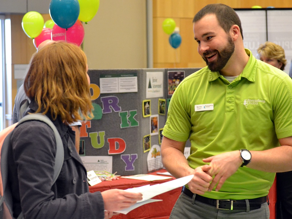 A SPEA student hands out information at a career fair.